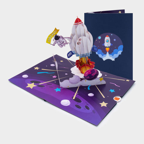 Aufgeklappte Rakete Pop-Up Karte mit startender 3D-Rakete und Sternen, daneben das Cover