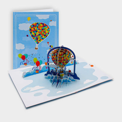 Aufgeklappte 3D Pop-Up Karte mit Heißluftballon aus bunten Luftballons, daneben die zugeklappte Karte mit Ballon-Motiv auf blauem Cover.