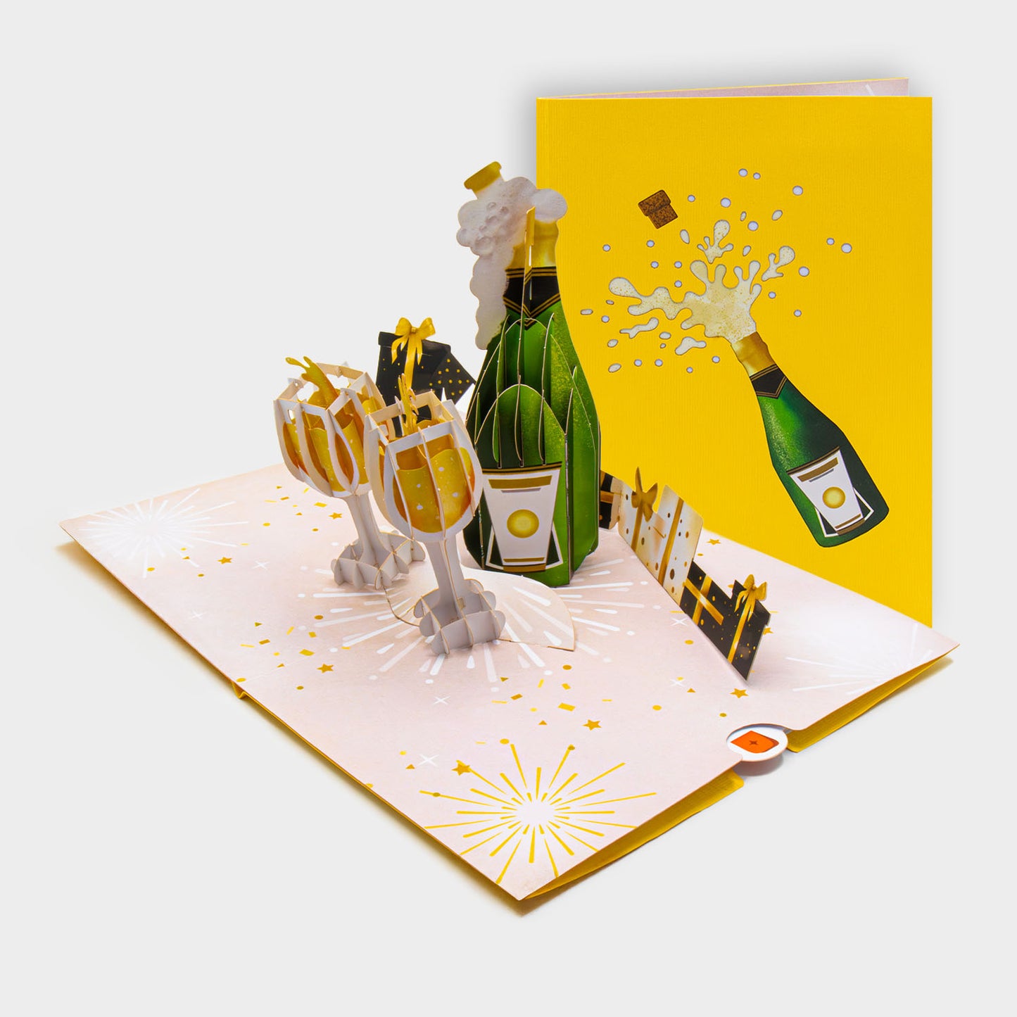 Aufgeklappte 3D Pop-Up Karte mit Champagnerflasche und Gläsern, daneben die zugeklappte Karte mit Sekt-Motiv auf gelbem Cover